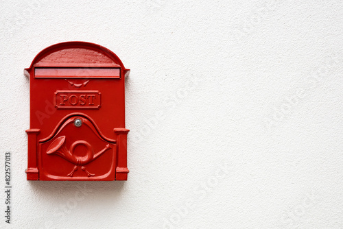 Traditional bright red post box on white plaster texture wall in Hungry. Metal mailbox with text POST in English language. Copy space