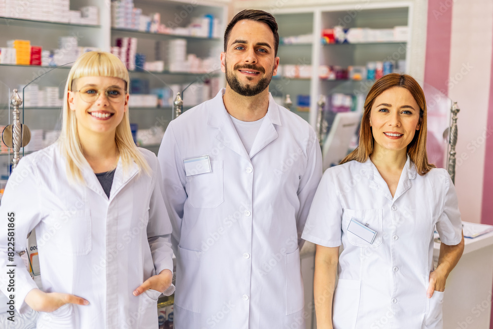 Fototapeta premium Portrait of three smiling pharmacists that are standing in the pharmacy.