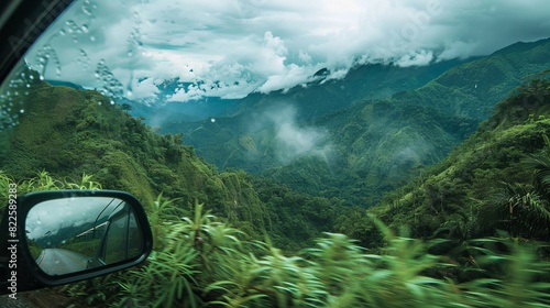 A scenic view of mountains and greenery reflected in a car's side mirror.