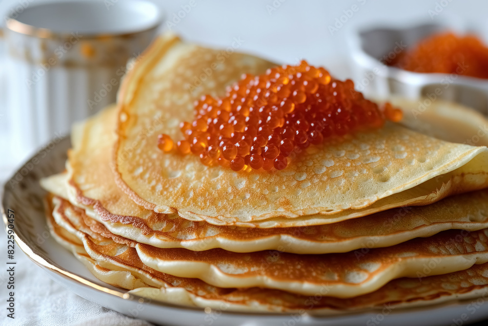 Homemade thin pancakes decorated with red caviar on white plate on cozy background, festive dish for maslenitsa week Homemade thin pancakes decorated with red caviar on white plate on cozy background, festive dish for maslenitsa week