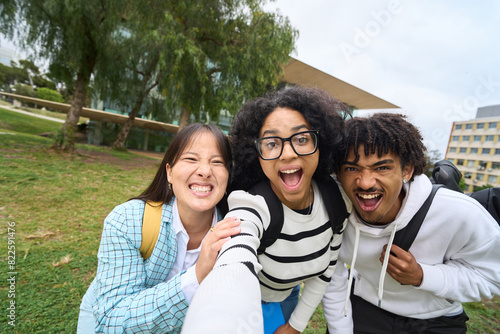 three young multiethnic students taking selfie