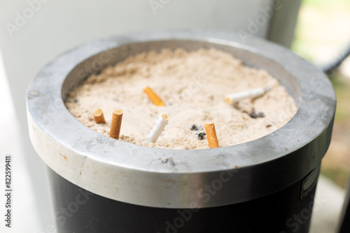 Smoked cigarettes in sandy ashtray