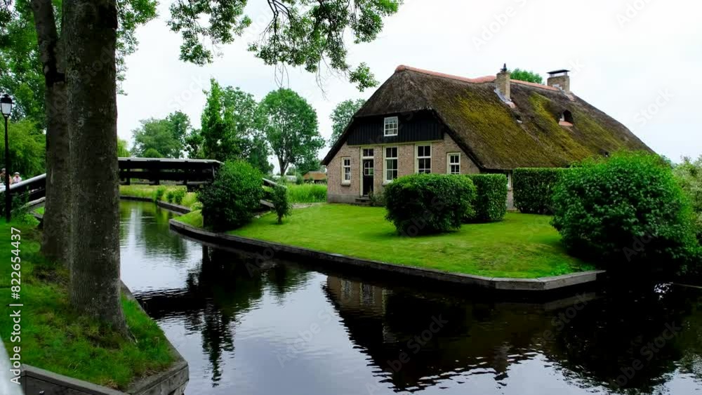 Traditional Dutch waterfront house on a canal in the village of Giethoorn, Netherlands. Traditional Dutch waterfront house on a canal in the village of Giethoorn, Netherlands.