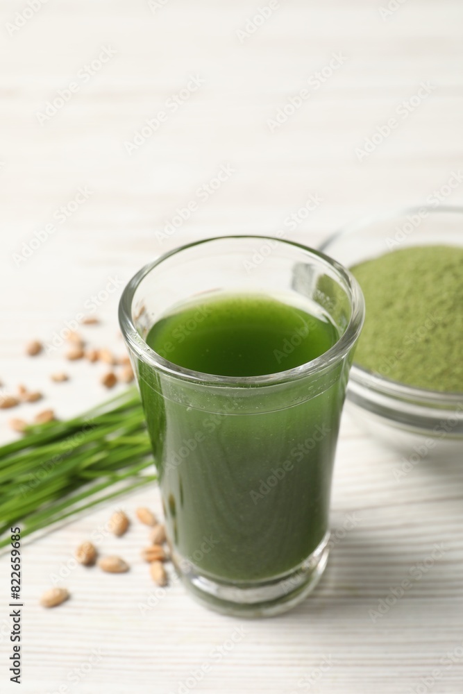 Wheat grass drink in shot glass on white wooden table, closeup Wheat grass drink in shot glass on white wooden table, closeup