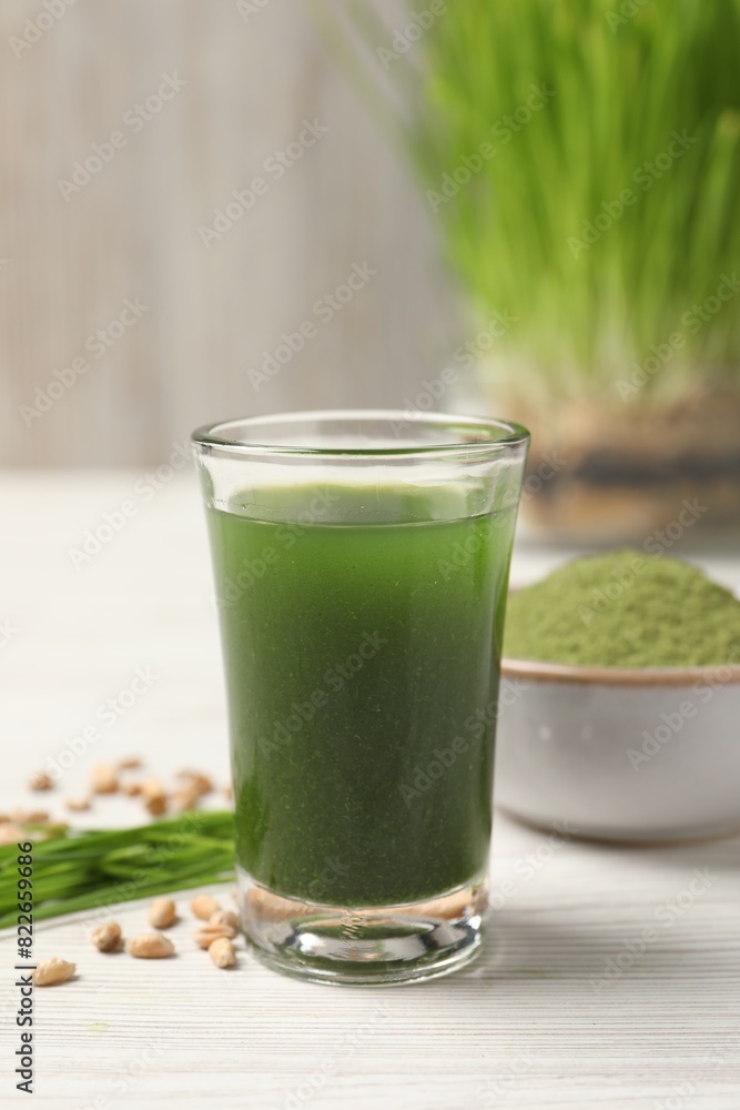 Wheat grass drink in shot glass on white wooden table, closeup Wheat grass drink in shot glass on white wooden table, closeup