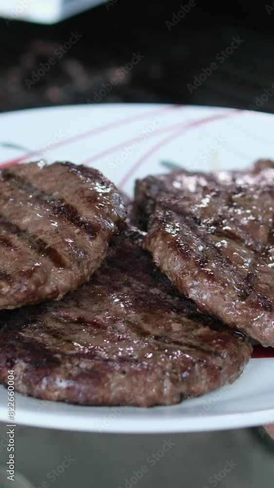 Two burger patties char and smoke on grill grates over open flame in commercial restaurant kitchen. slow motion. 4k Two burger patties char and smoke on grill grates over open flame in commercial restaurant kitchen. slow motion. 4k