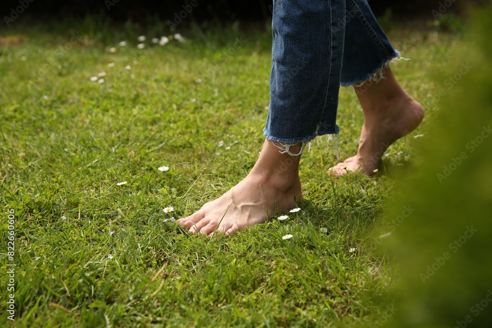 Woman walking barefoot on green grass outdoors, closeup Woman walking barefoot on green grass outdoors, closeup
