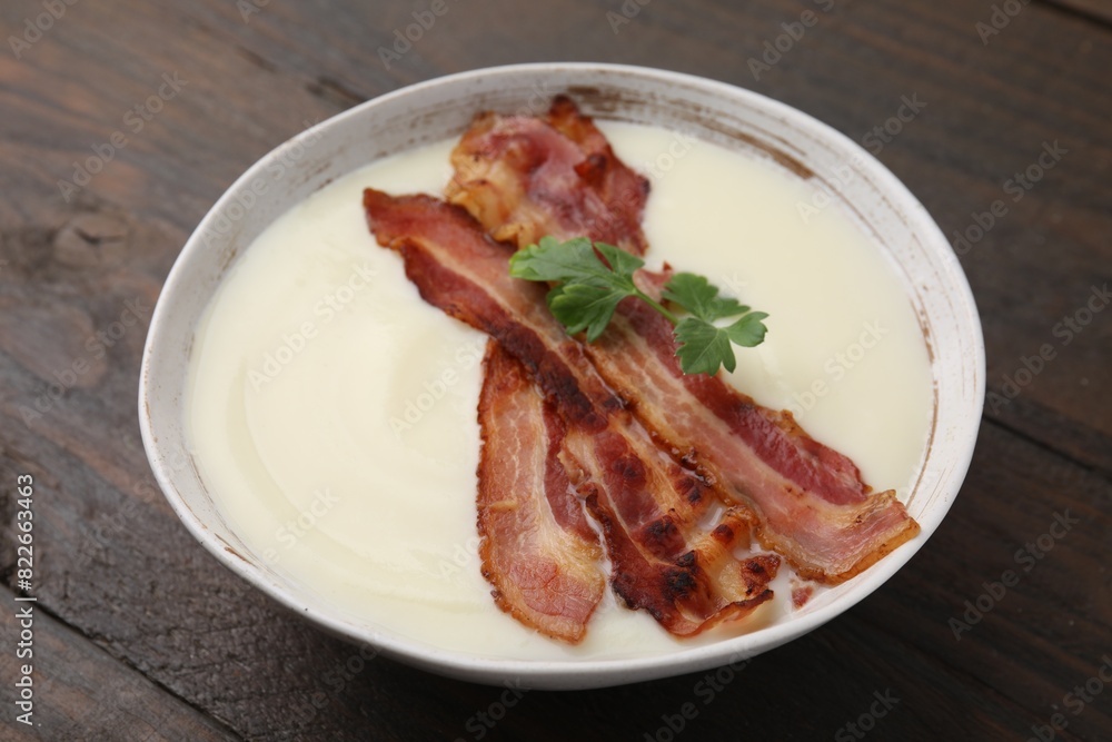 Delicious potato soup with bacon and parsley on wooden table Delicious potato soup with bacon and parsley on wooden table
