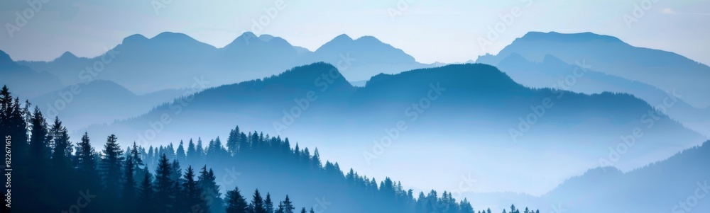 Mountains are covered in mist and fog with trees in the foreground