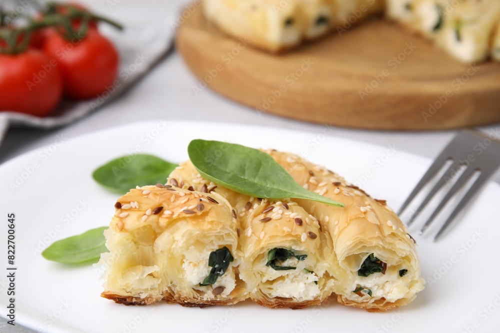 Piece of delicious puff pastry with spinach on table, closeup Piece of delicious puff pastry with spinach on table, closeup