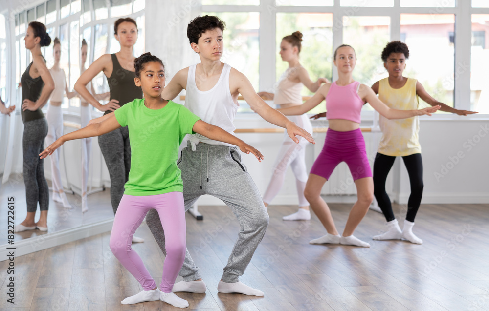 Obraz premium Couple teenage boy and girl dancers rehearsing pair ballet in studio