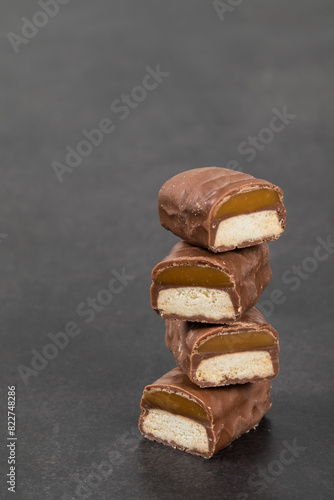Cookie bar with caramel in chocolate glaze. In the section. Dark background. Copy space