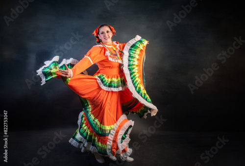 Mexican woman with escaramusa costume jalisco mexico orange color A woman in a colorful dress is dancing © ClicksdeMexico