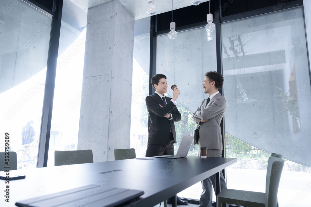 Businessman having a meeting or standing in an office Wide angle Businessman having a meeting or standing in an office Wide angle