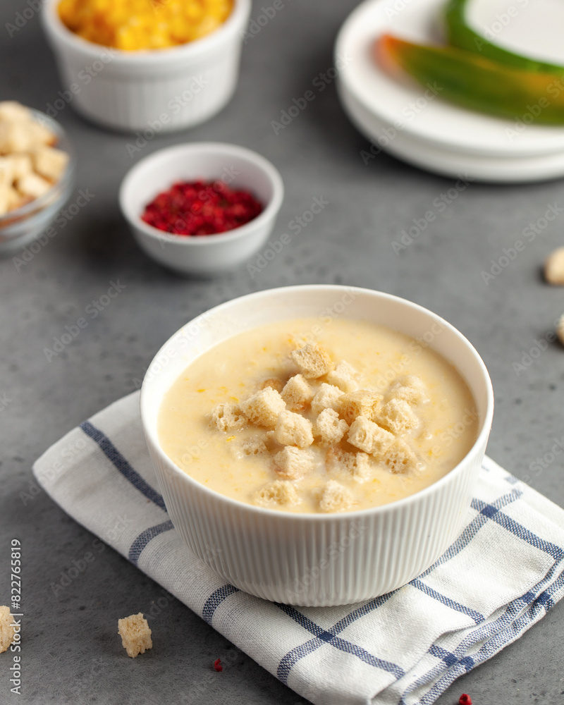 Creamy corn soup topped with croutons, offering a warm and comforting meal Creamy corn soup topped with croutons, offering a warm and comforting meal