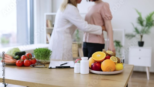 Close up view of woman in doctor's coat finding out waist length of female patient with measuring tape in consulting room. Efficient dietitian calculating body mass index for assessing healthy weight. photo