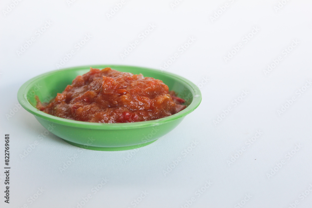 Portrait of tomato chili sauce in a green bowl isolated on a white background. Portrait of tomato chili sauce in a green bowl isolated on a white background.