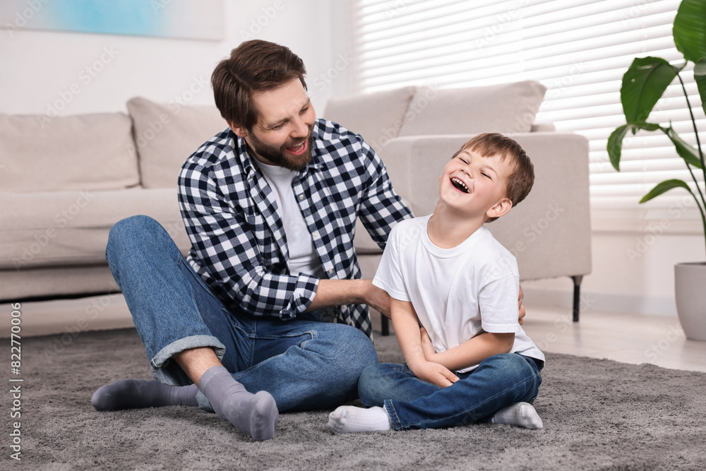 Happy dad and son having fun on carpet at home Happy dad and son having fun on carpet at home