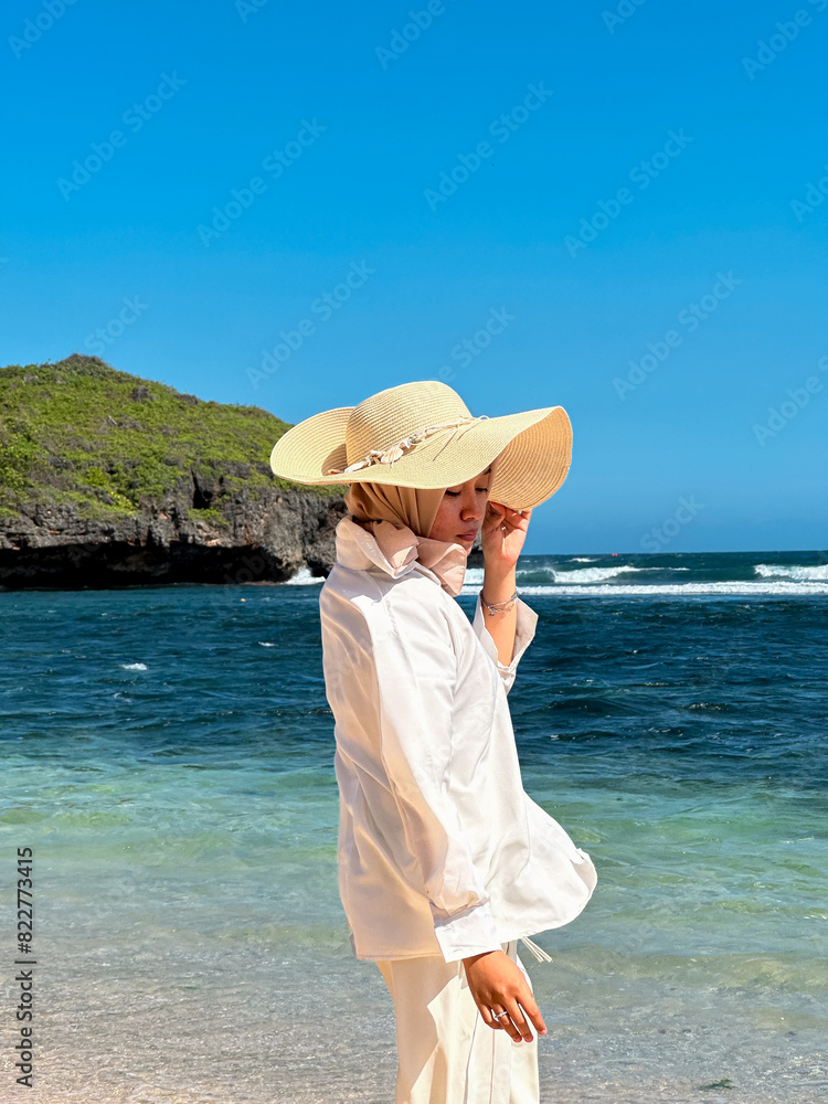 Indonesian young woman in hijab enjoying holiday on the beach Indonesian young woman in hijab enjoying holiday on the beach