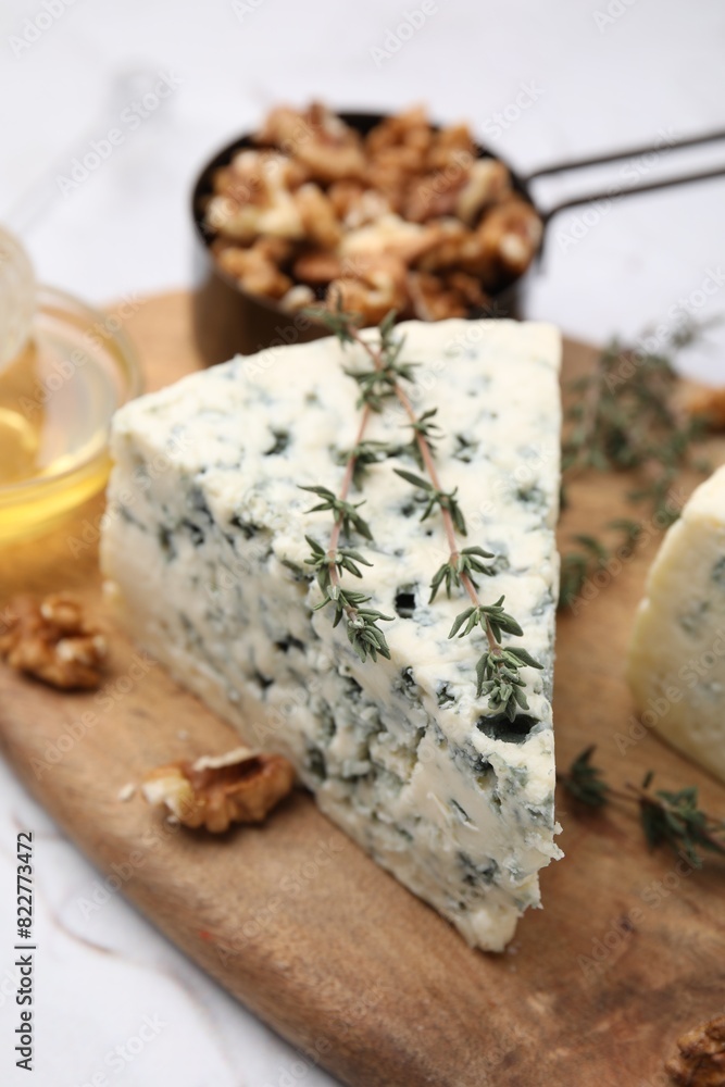 Tasty blue cheese with thyme, honey and walnuts on white table Tasty blue cheese with thyme, honey and walnuts on white table