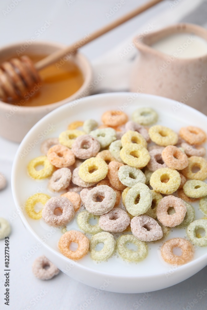 Cereal rings and milk in bowl on white table, closeup Cereal rings and milk in bowl on white table, closeup