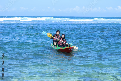 indonesian Young couple canoeing enjoying holiday on the beach