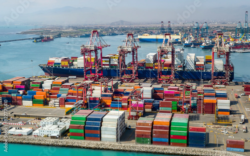 Aerial view of the port of Callao in Lima, Peru, showing port activity with containers and cranes in full operation. In the background can be seen the city and the Pacific Ocean