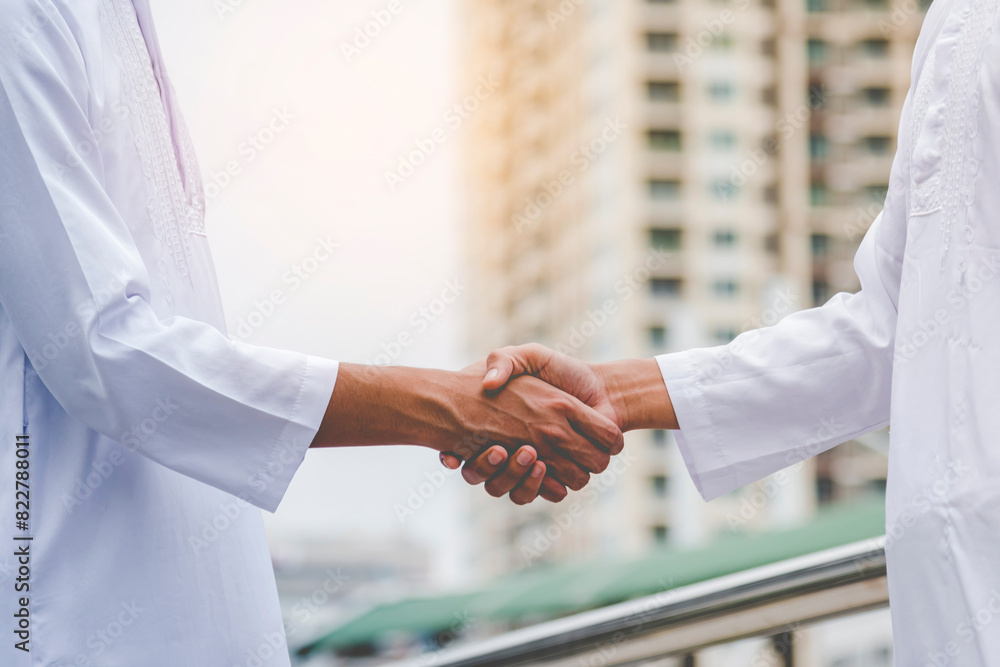 Arab Businessman shaking hands together. Teamwork business partner wear Muslim dress Shake Hands with Partnership Concept. Success UAE diversity people trust make commitment by handshake Arab Businessman shaking hands together. Teamwork business partner wear Muslim dress Shake Hands with Partnership Concept. Success UAE diversity people trust make commitment by handshake
