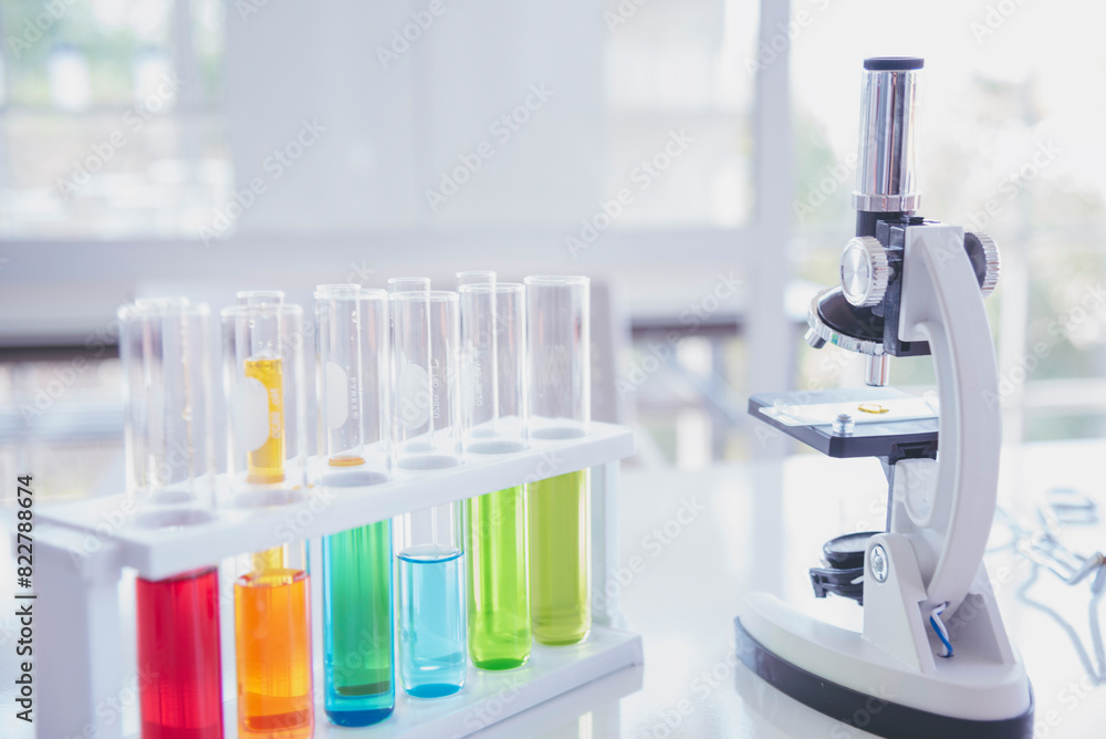 Science laboratory chemistry test science lab with microscope, glass tubes, chemical beaker white table scientific background. Colorful Liquid biology laboratory chemical fluid scientist experiment