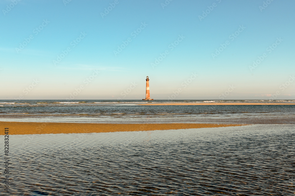 Fototapeta premium Morris Island Lighthouse from the shoreline of Folly Beach near Charleston, South Carolina.