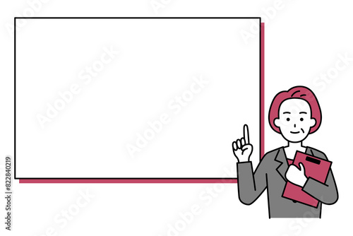 ホワイトボードの前でクリップボードを持って説明する年配のスーツの女性