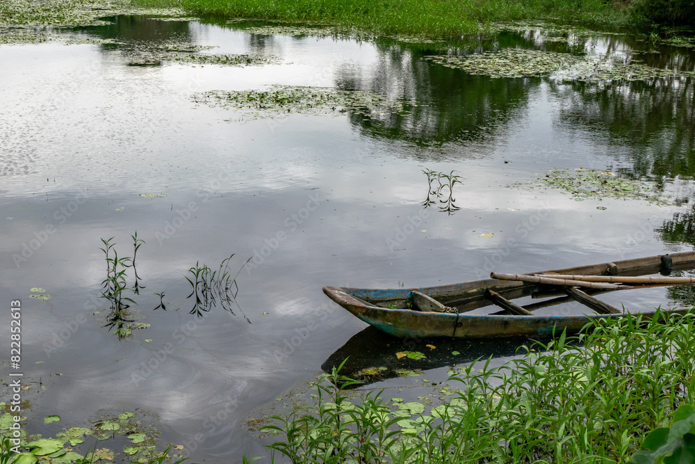 Peaceful lake with plants and wood boat on the water, in New Taipei City, Taiwan. Peaceful lake with plants and wood boat on the water, in New Taipei City, Taiwan.