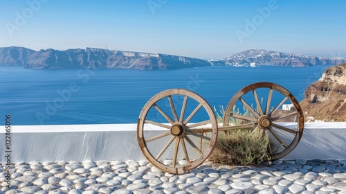 wooden cart wheel on white roof of Santorini with blue sea in the background,