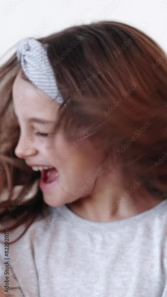 Vertical video. Happy child. Kid rejoice. Excited enthusiastic little girl enjoying entertainment turning head smiling isolated on white background. Vertical video. Happy child. Kid rejoice. Excited enthusiastic little girl enjoying entertainment turning head smiling isolated on white background.