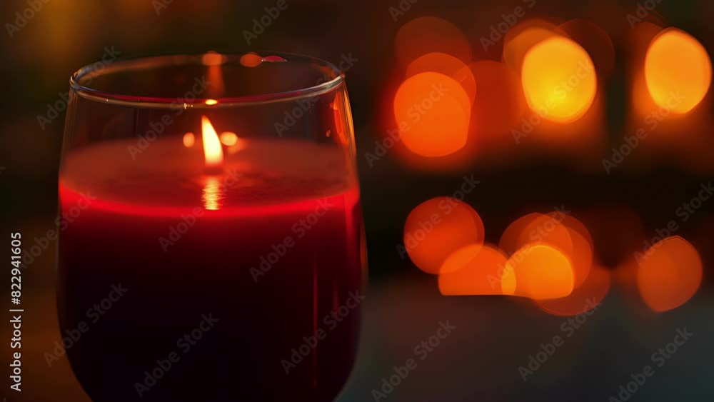 A closeup of a glass filled with a vibrant red juice reflecting the soft glow of candlelight. A closeup of a glass filled with a vibrant red juice reflecting the soft glow of candlelight.
