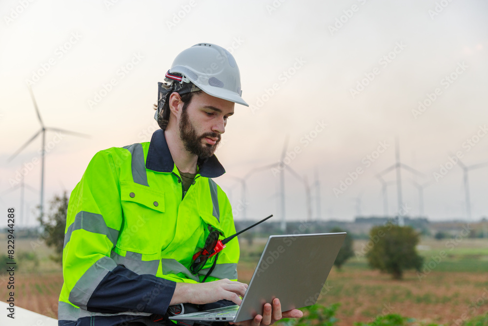 Engineer wearing safety uniform holding laptop discussed plan about renewable energy at station energy power wind. technology protect environment reduce global warming problems. Engineer wearing safety uniform holding laptop discussed plan about renewable energy at station energy power wind. technology protect environment reduce global warming problems.