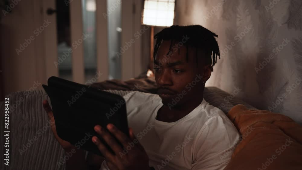 Young black male selects something to watch on his tablet device Young black male selects something to watch on his tablet device
