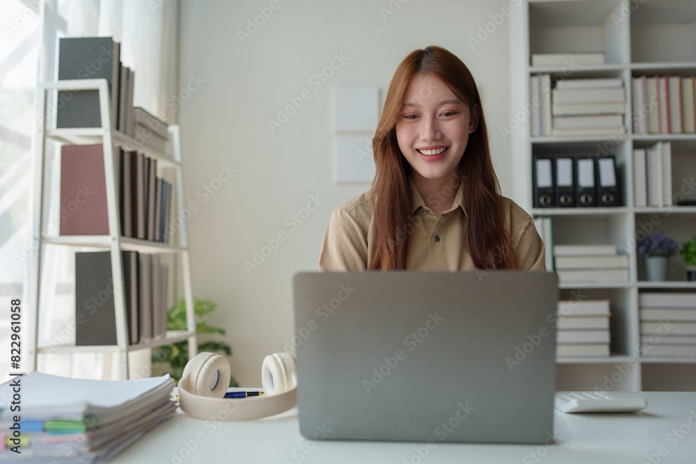 Asian businesswoman sits and works with laptop in contacting customers online. View details and discuss financial business information. Happiness in wealth Success in the office. Asian businesswoman sits and works with laptop in contacting customers online. View details and discuss financial business information. Happiness in wealth Success in the office.