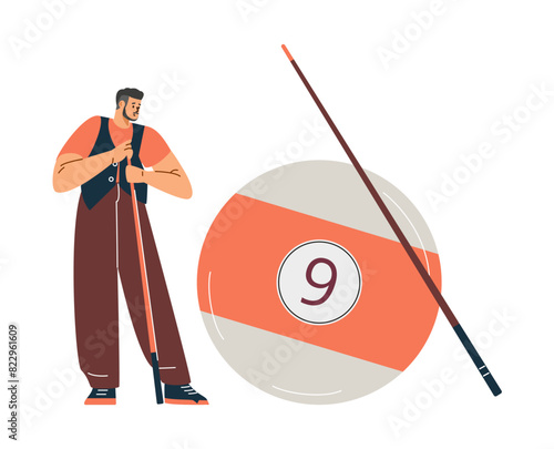 A male billiard player with a cue stands near a large billiard ball with the number six or nine.