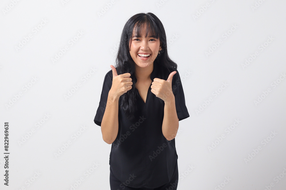 Portrait of attractive Asian woman in casual shirt making thumb up hand gesture, saying good job. Businesswoman concept. Isolated image on white background Portrait of attractive Asian woman in casual shirt making thumb up hand gesture, saying good job. Businesswoman concept. Isolated image on white background