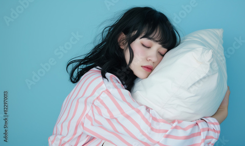 枕を持って寝ているパジャマ姿の女性