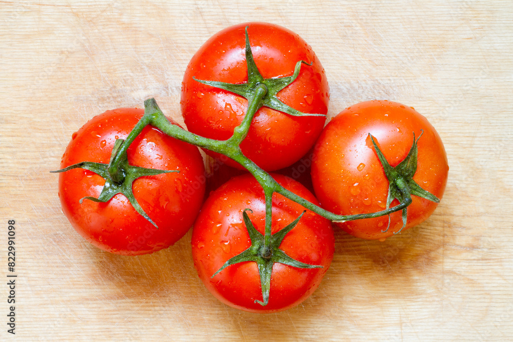 Large red tomatoes on a wooden surface. Natural organic tomatoes. Wet tomatoes close-up. Large red tomatoes on a wooden surface. Natural organic tomatoes. Wet tomatoes close-up.