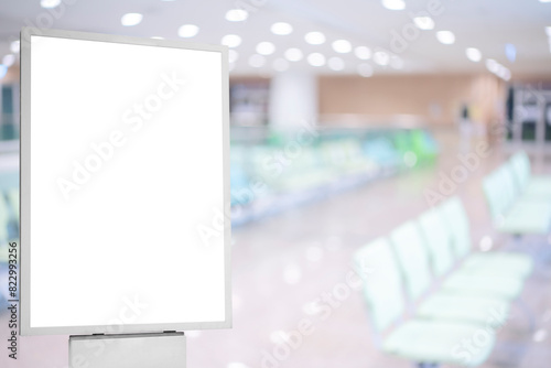 A mockup of an empty white poster on the wall in modern hospital waiting room with comfortable chairs and medical.