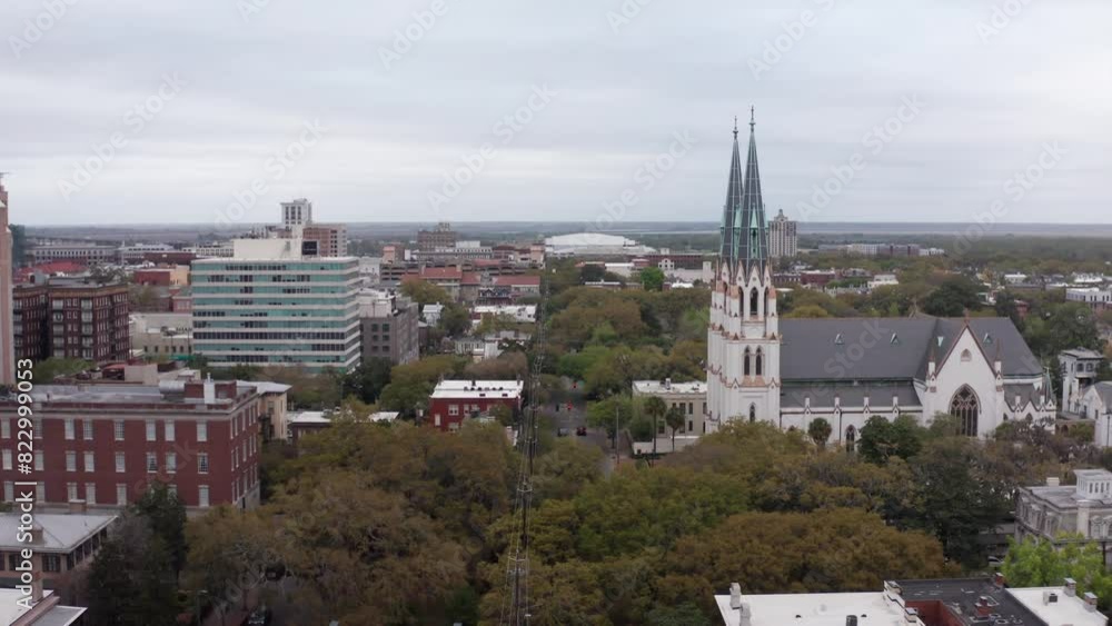 Low aerial shot flying over the famous city squares of Savannah, Georgia towards the Cathedral Basilica of Saint John the Baptist. 4K Low aerial shot flying over the famous city squares of Savannah, Georgia towards the Cathedral Basilica of Saint John the Baptist. 4K