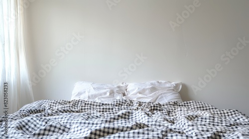  A bed with a black-and-white checkered comforter Behind it, a window