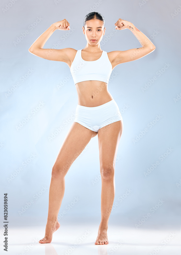 Arms, fitness and portrait of woman in underwear on studio gray background for health or natural wellness. Biceps, body and exercise with gesture of serious of strong athlete for power or training Arms, fitness and portrait of woman in underwear on studio gray background for health or natural wellness. Biceps, body and exercise with gesture of serious of strong athlete for power or training
