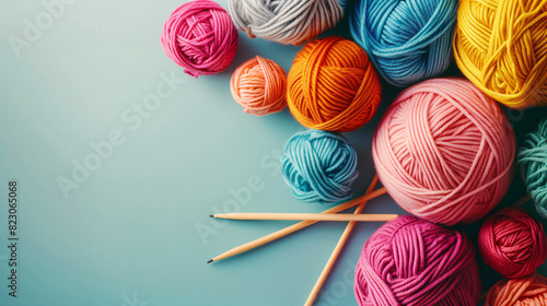 Colorful yarn balls and knitting needles. Colorful yarn balls and knitting needles on a blue background, perfect for craft and hobby projects.