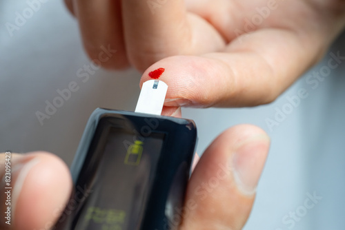 Woman's hands checking diabetes and hyperglycemia with digital blood sugar meter. Healthcare and medical concept