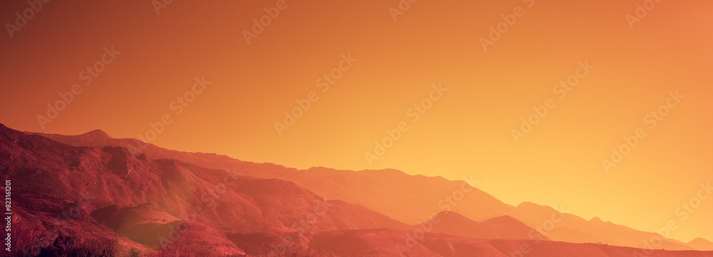 Silhouette of mountains against the orange sunset sky. Horizontal banner Silhouette of mountains against the orange sunset sky. Horizontal banner