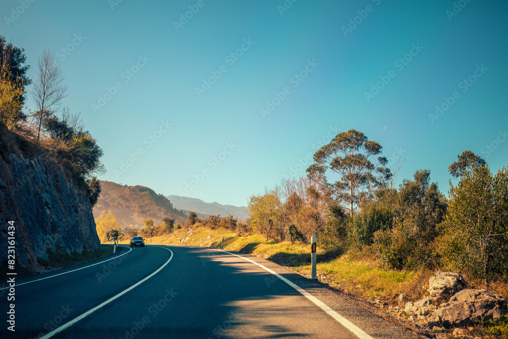 View of a beautiful mountain landscape through the windshield on a sunny day. Driving a car on a mountain road in the Picos de Europa National Park. Cantabria, Spain, Europe